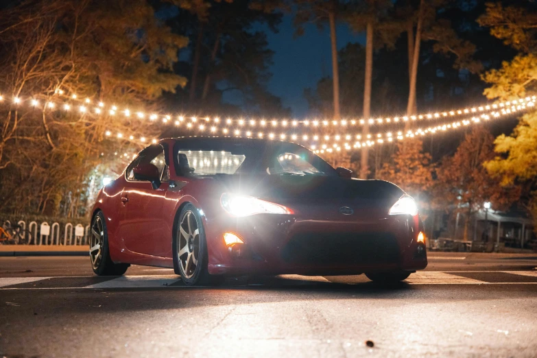 a red sports car driving down a street at night, a portrait, unsplash, renaissance, in the woods at night, toyota supra, 8 k highly detailed ❤🔥 🔥 💀 🤖 🚀, avatar image