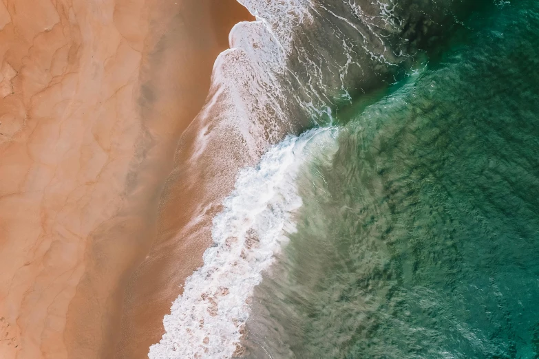 a person riding a surfboard on top of a sandy beach, pexels contest winner, bird\'s eye view, rippling oceanic waves, 4 k hd wallpapear, photo of green river