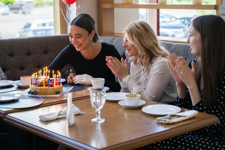 a group of women sitting at a table with a cake, profile image, happy birthday candles, background image, multiple stories