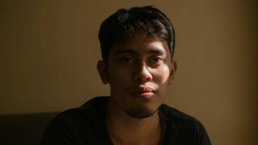 a man sitting in front of a laptop computer, a character portrait, by Basuki Abdullah, pexels contest winner, light stubble, halfbody headshot, very low light, ((portrait))