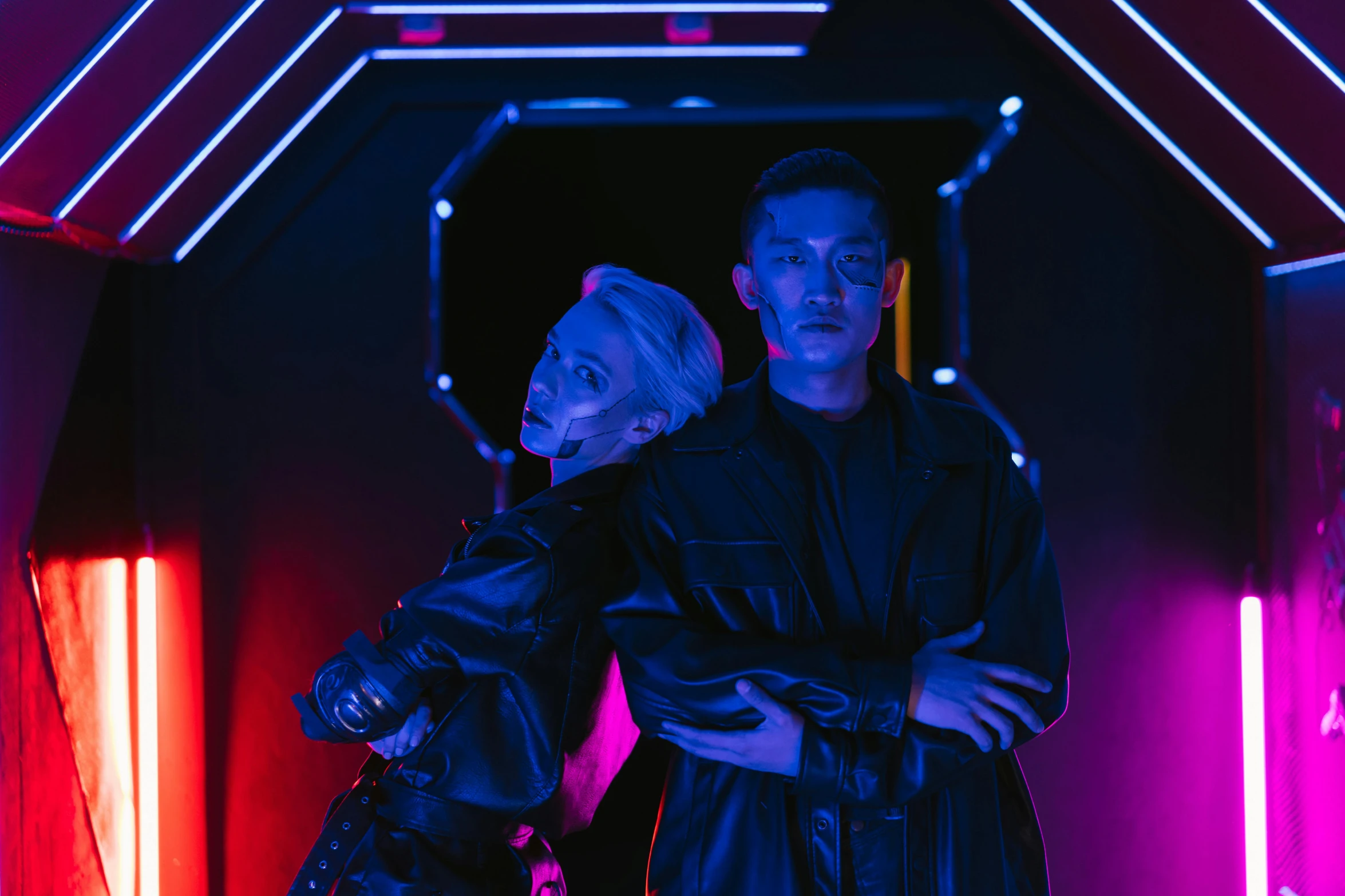 two people standing next to each other in neon lights, cyberpunk art, pexels, antipodeans, die antwoord style wear, family photo, all black cyberpunk clothes, geometric backdrop; led