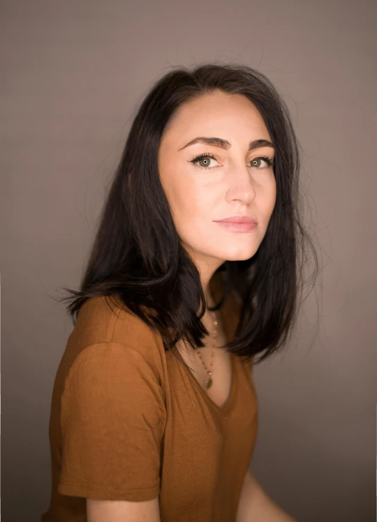 a woman in a brown shirt posing for a picture, a character portrait, by Arabella Rankin, headshot profile picture, artem chebokha, mid length portrait photograph, profile image