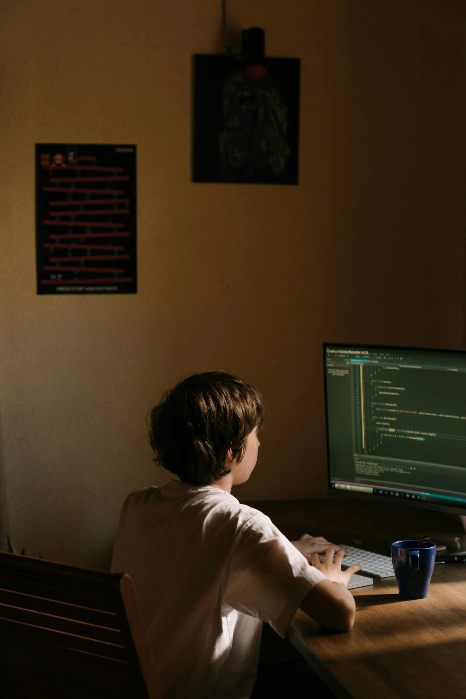 a person sitting at a desk in front of a computer, future coder looking on, at home, lachlan bailey, no cropping
