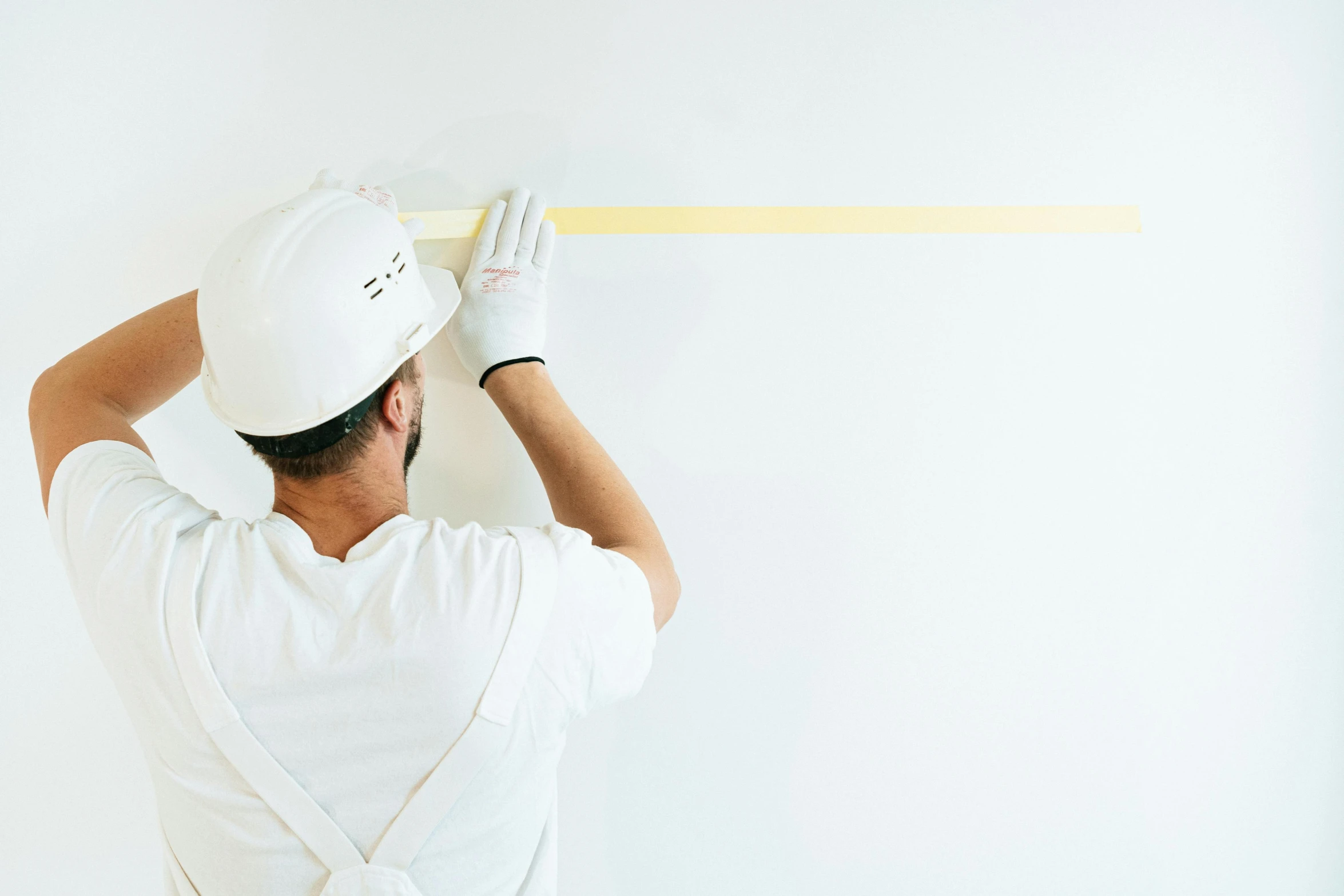 a man is measuring a wall with a tape, a minimalist painting, by Everett Warner, trending on pexels, teaser, white backdrop, on a yellow canva, developers