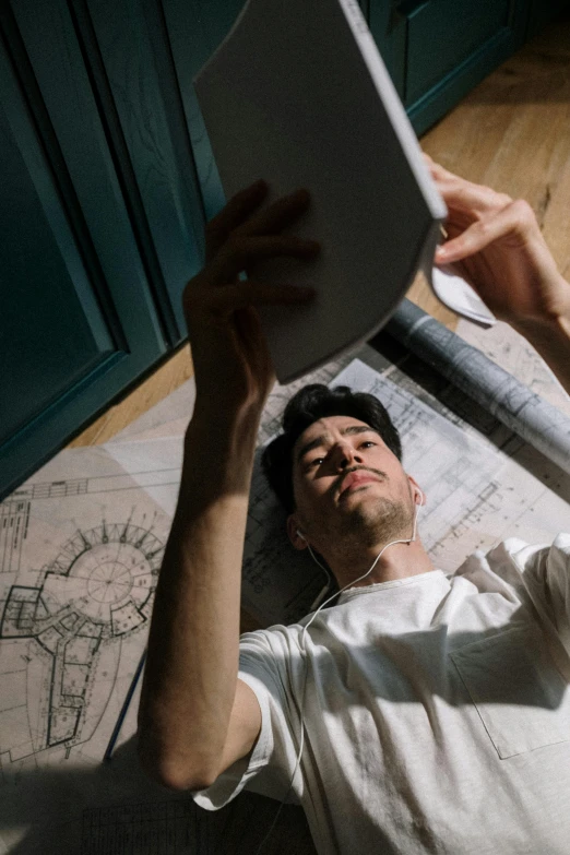 a man laying on the floor with a laptop, pexels contest winner, conceptual art, architectural plans, iphone selfie, carpenter, lean man with light tan skin