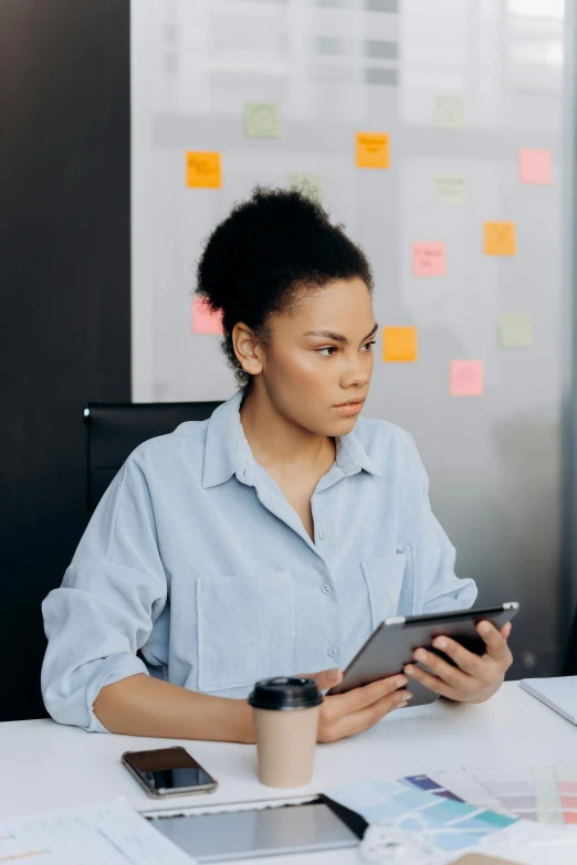 a woman sitting at a desk using a tablet computer, pexels, nathalie emmanuel, serious business, multiple stories, maintenance