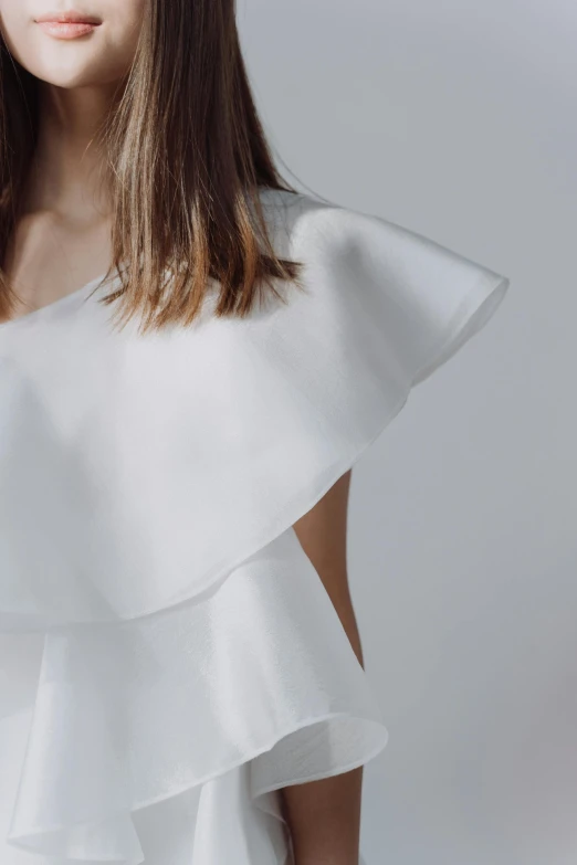 a woman in a white dress posing for a picture, an album cover, inspired by Modest Urgell, trending on pexels, crop top, ruffles, detailed close up shot, in elegant decollete