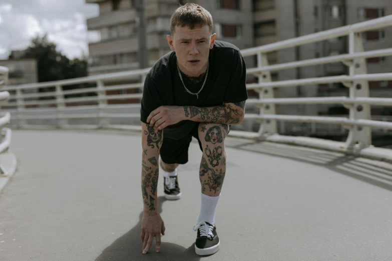 a man sitting on a skateboard on a bridge, a tattoo, inspired by Seb McKinnon, pexels contest winner, yung lean, standing in a city street, working out, portrait image