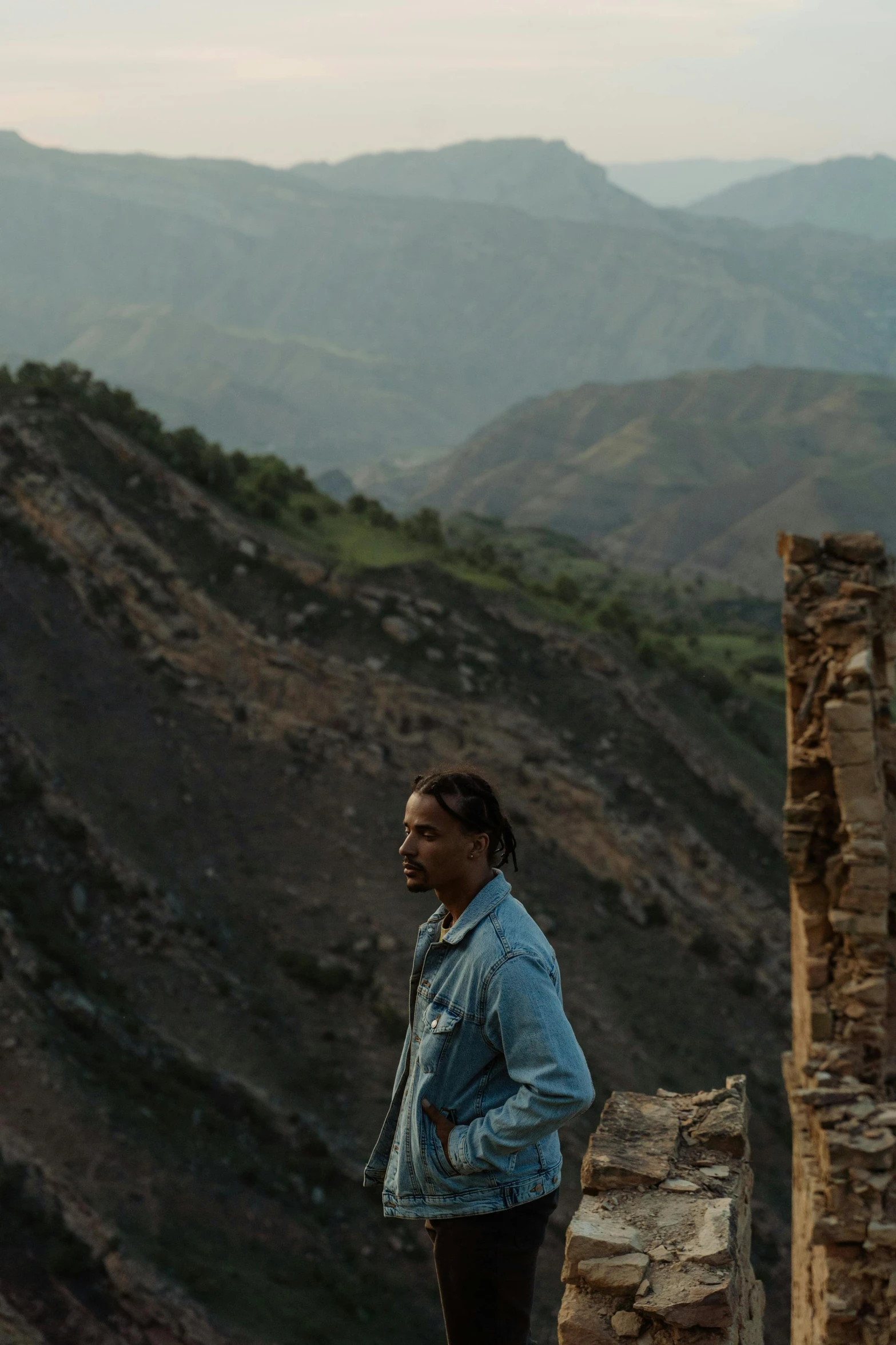 a woman standing at the top of a mountain, by Afewerk Tekle, les nabis, photo of a man, the ruins, looking to the side off camera, : kendrick lamar