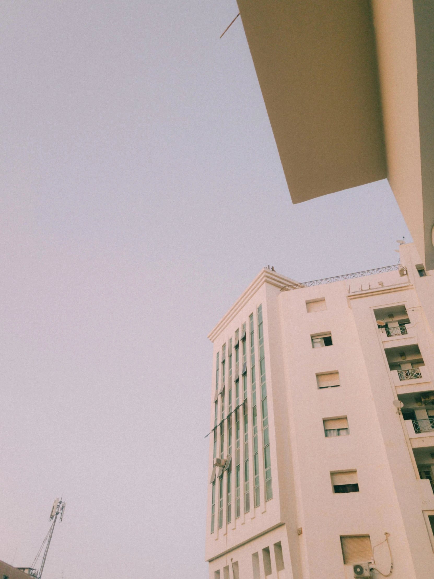 a man flying through the air while riding a skateboard, a polaroid photo, unsplash, postminimalism, big poor building, moroccan city, ((oversaturated)), multistory building