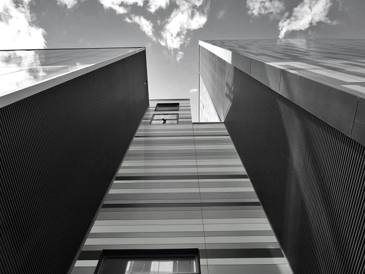 a black and white photo of a tall building, inspired by Bauhaus, unsplash, metal cladding wall, skies, stripes, monochrome 3 d model