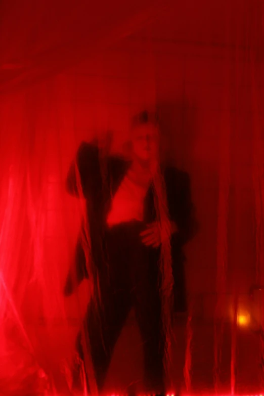 a man standing in front of a red light, spirits covered in drapery, heavy jpeg artifact blurry, antichrist dancing at studio 54, red webs
