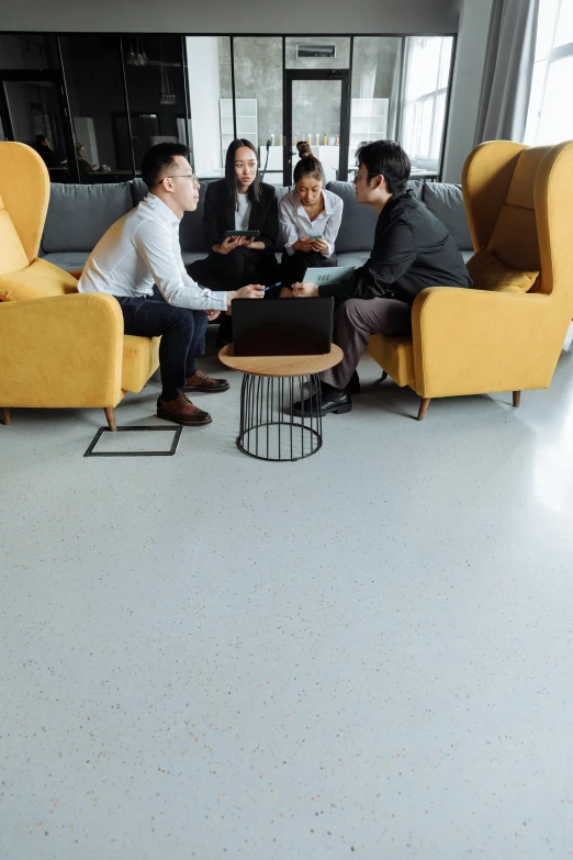 a group of people sitting around a yellow couch, pexels, modernism, polished concrete, business meeting, thumbnail, 4l