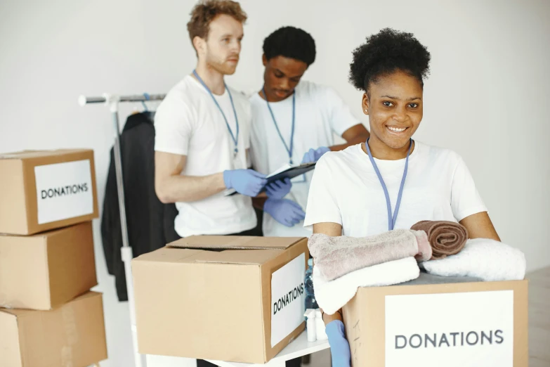 a group of people standing around a pile of boxes, healthcare worker, dark-skinned, no duplicate image, local heroes