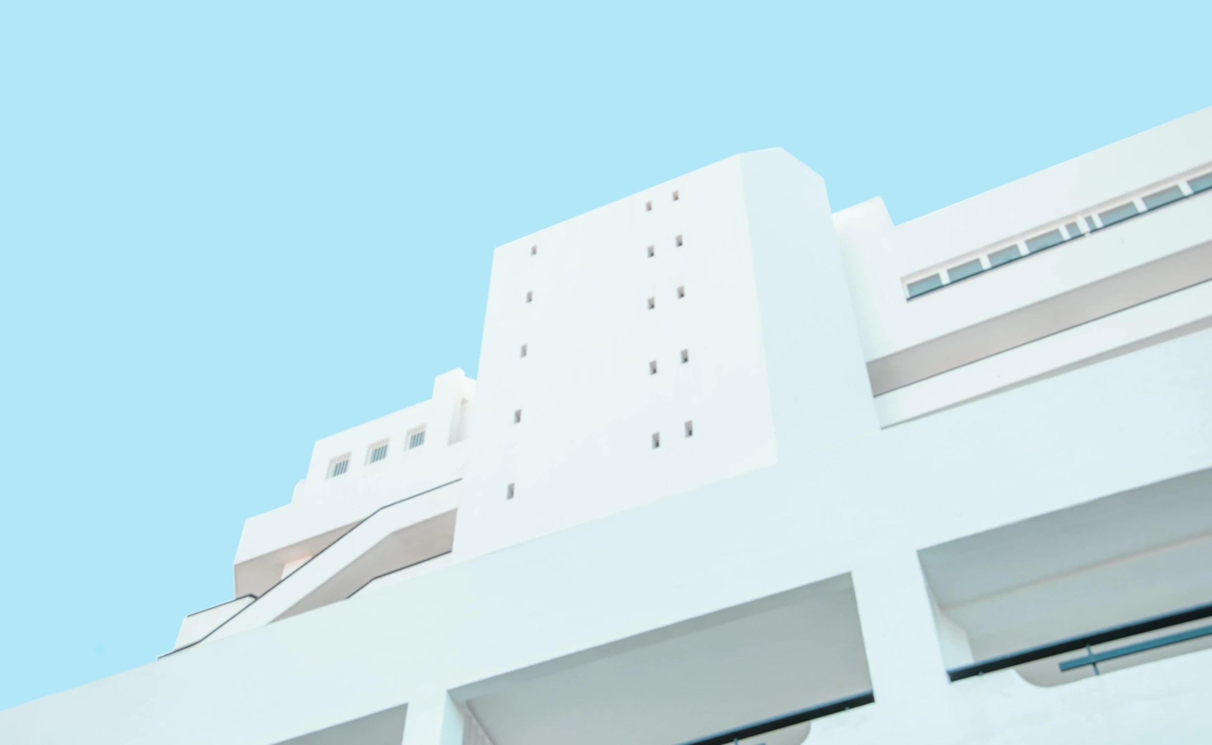 a tall white building with a blue sky in the background, a 3D render, inspired by Ricardo Bofill, unsplash, bauhaus, mediterranean architecture, japanese high school, white-space-surrounding, intricate image