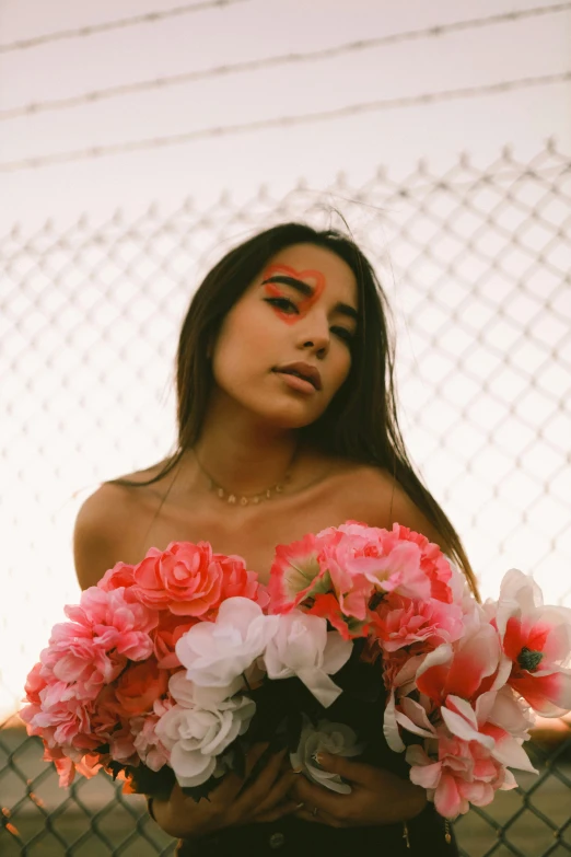 a woman holding a bunch of pink and white flowers, an album cover, inspired by Elsa Bleda, trending on pexels, graffiti, madison beer girl portrait, covered in coral, alanis guillen, still from a music video