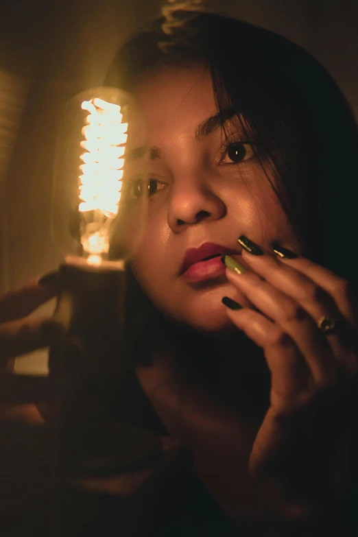 a woman holding a light bulb in front of her face, inspired by Elsa Bleda, pexels contest winner, lit with candles, looking seductive, light skin, reflective light