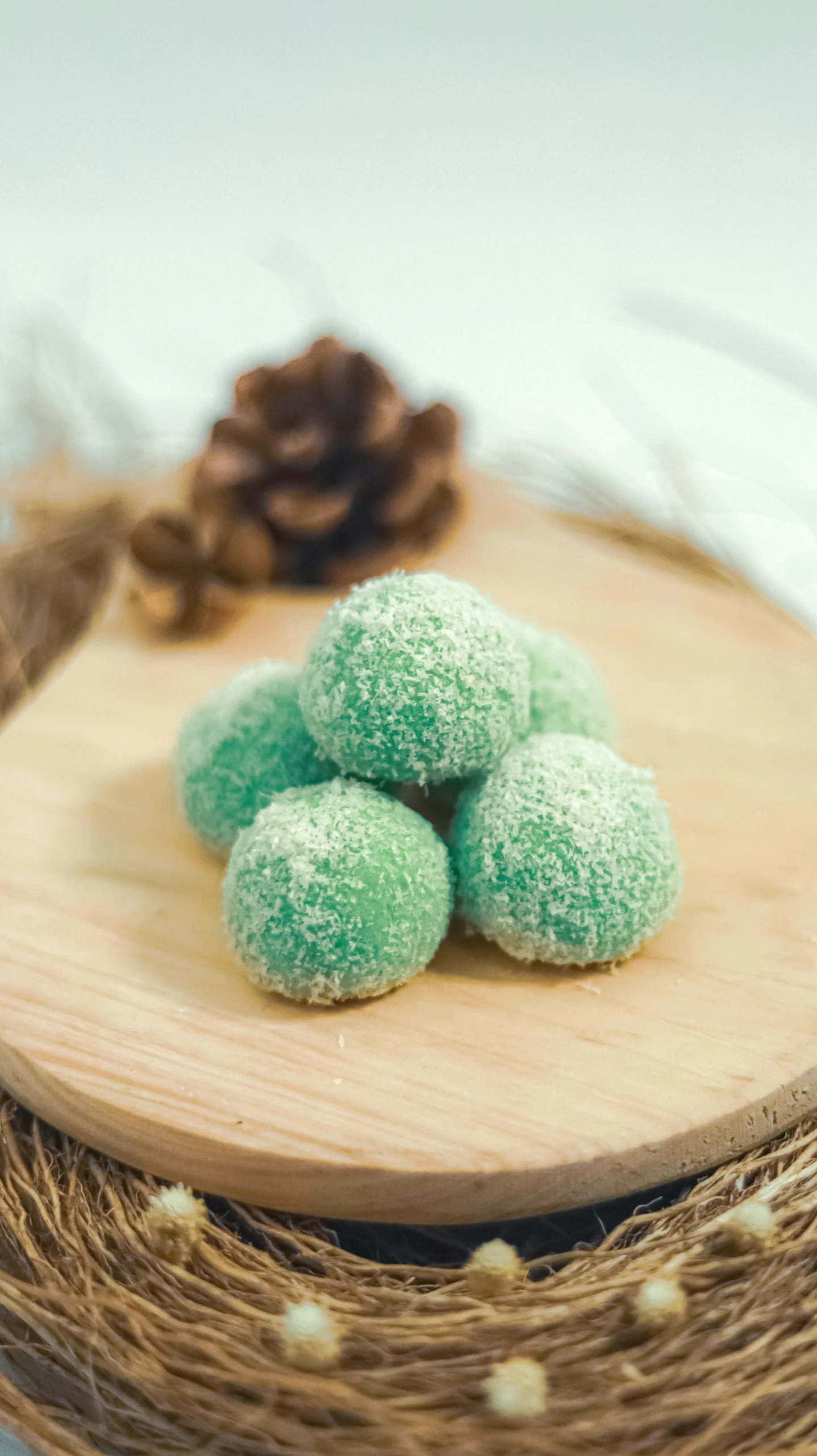a wooden plate topped with green doughnuts on top of a table, inspired by Lam Qua, unsplash, hurufiyya, gumdrops, indonesia, ice blue, high quality product photo