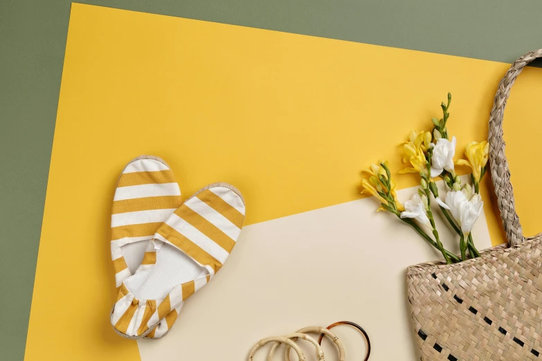 a straw bag sitting on top of a table next to a pair of flip flop flop flop flop flop flop flop flop flop flop flop flop flop, a still life, inspired by Esaias Boursse, unsplash contest winner, minimalism, white and yellow scheme, flat colour-block style, striped socks, flowers around