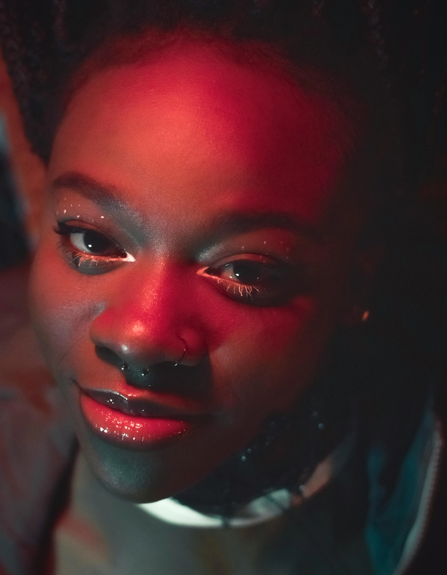 a close up of a person with a cell phone, inspired by Carrie Mae Weems, afrofuturism, police lights shine on her face, septum piercing, teenage girl, still from a music video