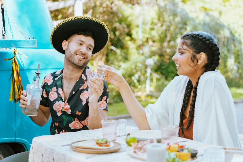 a man and a woman sitting at a table, pexels contest winner, wearing sombrero, charli bowater and artgeem, al fresco, lachlan bailey