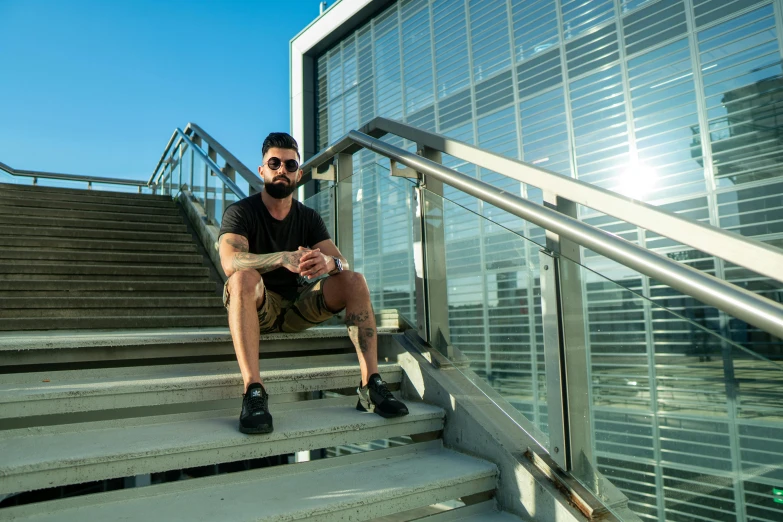 a man sitting on a set of stairs, by Niko Henrichon, pexels contest winner, hyperrealism, implanted sunglasses, bearded, super buff and cool, avatar image