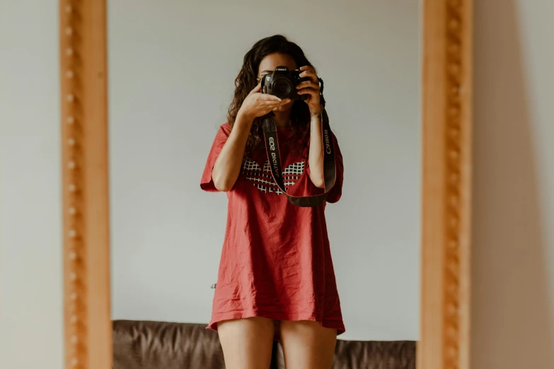 a woman taking a picture of herself in a mirror, pexels contest winner, red t-shirt, short dress, cinematic outfit photo, fully body photo