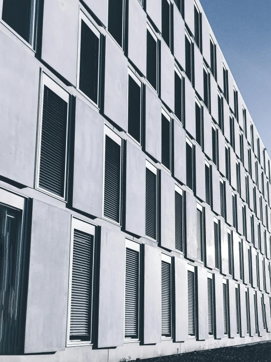a black and white photo of a building, inspired by David Chipperfield, pexels contest winner, blue shutters on windows, thumbnail, concrete, college