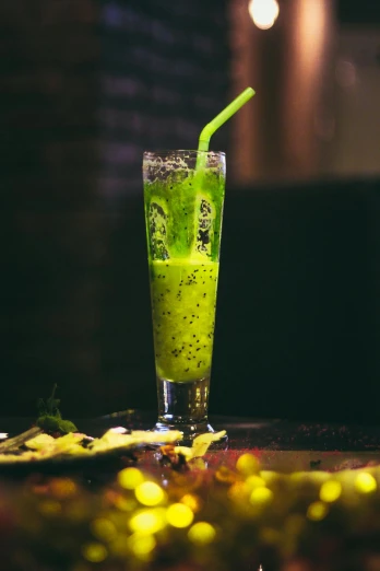 a green drink sitting on top of a table, by Peter Churcher, pexels, hurufiyya, 🐿🍸🍋, milkshake, black and green, lit from the side