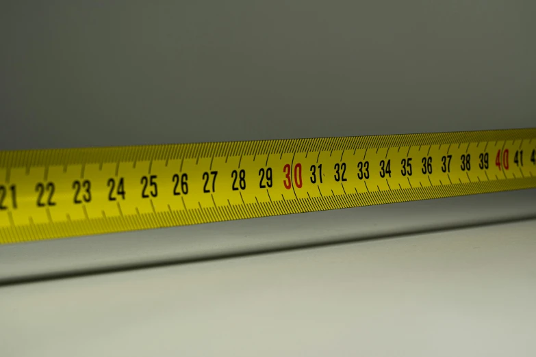 a measuring tape sitting on top of a table, close to the camera