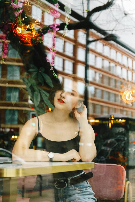 a woman sitting at a table talking on a cell phone, a picture, inspired by Elsa Bleda, trending on unsplash, realism, transparent glass woman, in london, pale skin, an asian woman