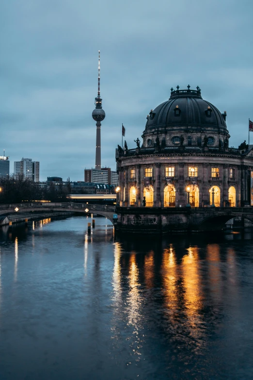 a large building sitting on top of a river next to a bridge, pexels contest winner, berlin secession, neoclassical tower with dome, gloom and lights, casually dressed, cozy