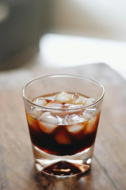 a close up of a drink in a glass on a table, cold brew coffee ), ignant, zoomed in, flattened