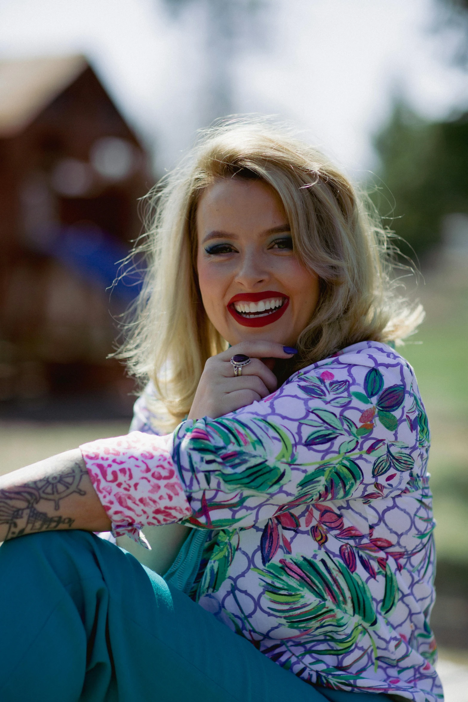 a woman sitting on the ground next to a fire hydrant, a portrait, inspired by Ivana Kobilca, graffiti, wearing a colorful coogi sweater, cheeky smile with red lips, 15081959 21121991 01012000 4k, kylie minogue