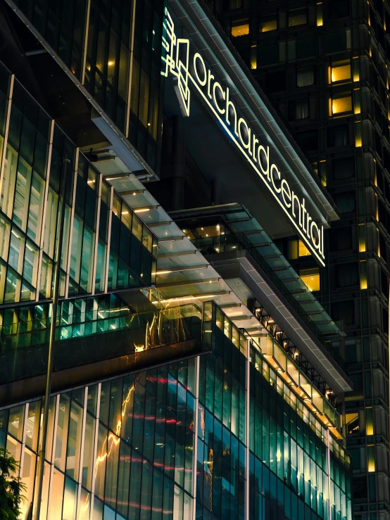 a tall building is lit up at night, by Peter Churcher, lots of glass details, marketing photo, portrait of gigachad, centralised