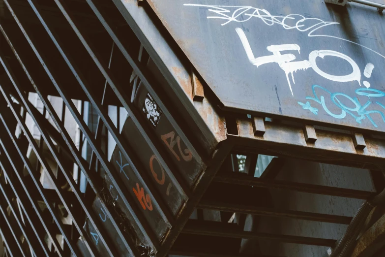 a close up of a building with graffiti on it, by Lee Loughridge, unsplash, graffiti, cyberpunk elevated train, instagram photo, steel and metal, background image