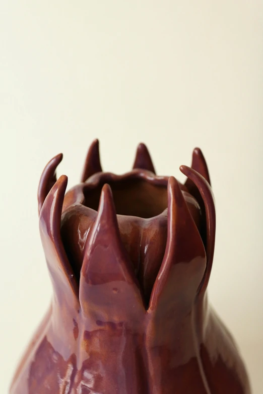 a close up of a vase on a table, a surrealist sculpture, by Jessie Algie, unsplash, process art, dark purple crown, bottom - view, made of glazed, dragon paw