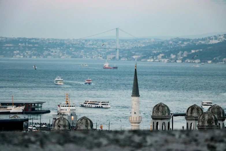 a large body of water with a bridge in the background, by Niyazi Selimoglu, pexels contest winner, hurufiyya, black domes and spires, subtitles, seaview, fan favorite