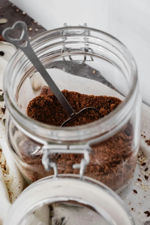 a close up of a jar of food on a table, soil, cappuccino, detailed product image, oud