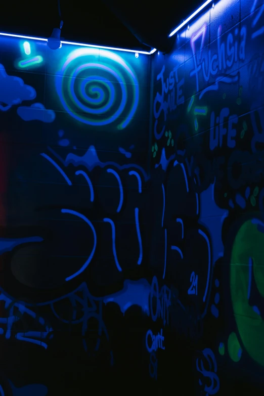 a man standing in front of a wall covered in graffiti, inspired by Ron English, graffiti, blue bioluminescence, slush!!, black light, blue sunshine