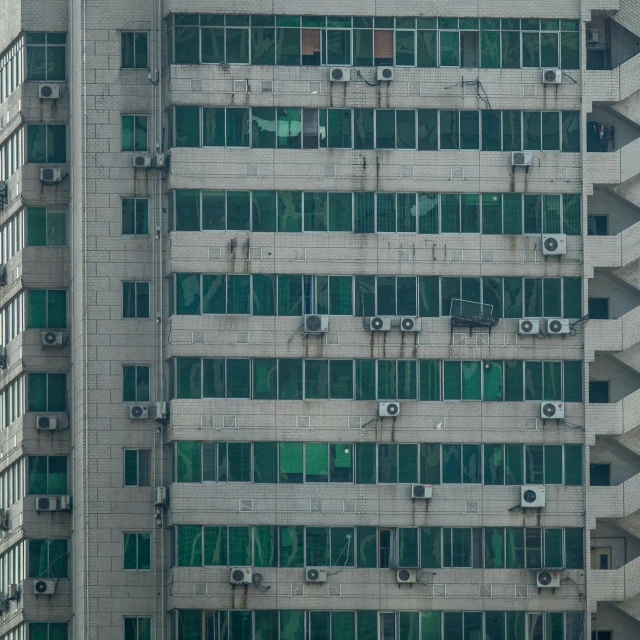 a very tall building with lots of windows, a photo, inspired by Elsa Bleda, pexels contest winner, brutalism, air conditioner, zezhou chen, telephoto long distance shot, a green