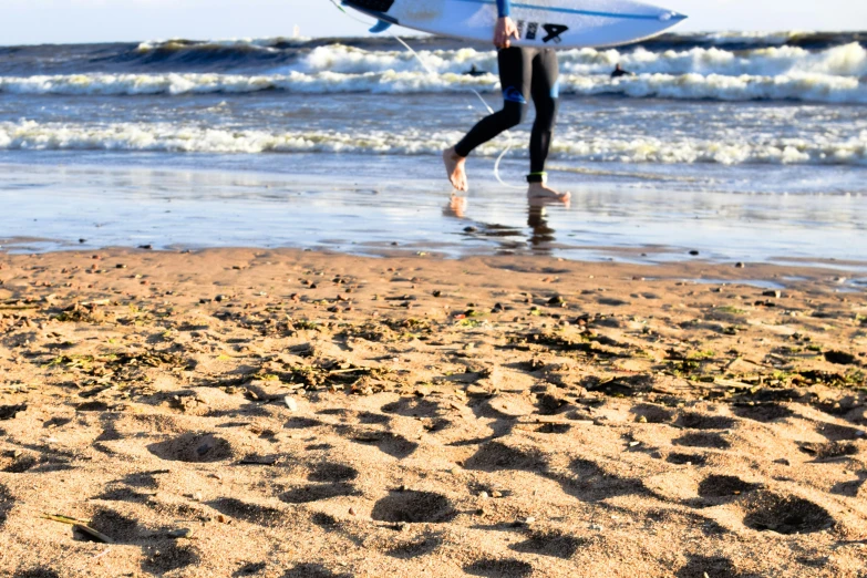 a man carrying a surfboard on top of a sandy beach, by Arabella Rankin, unsplash, happening, footprints in the sand, teenage girl, 15081959 21121991 01012000 4k, thumbnail