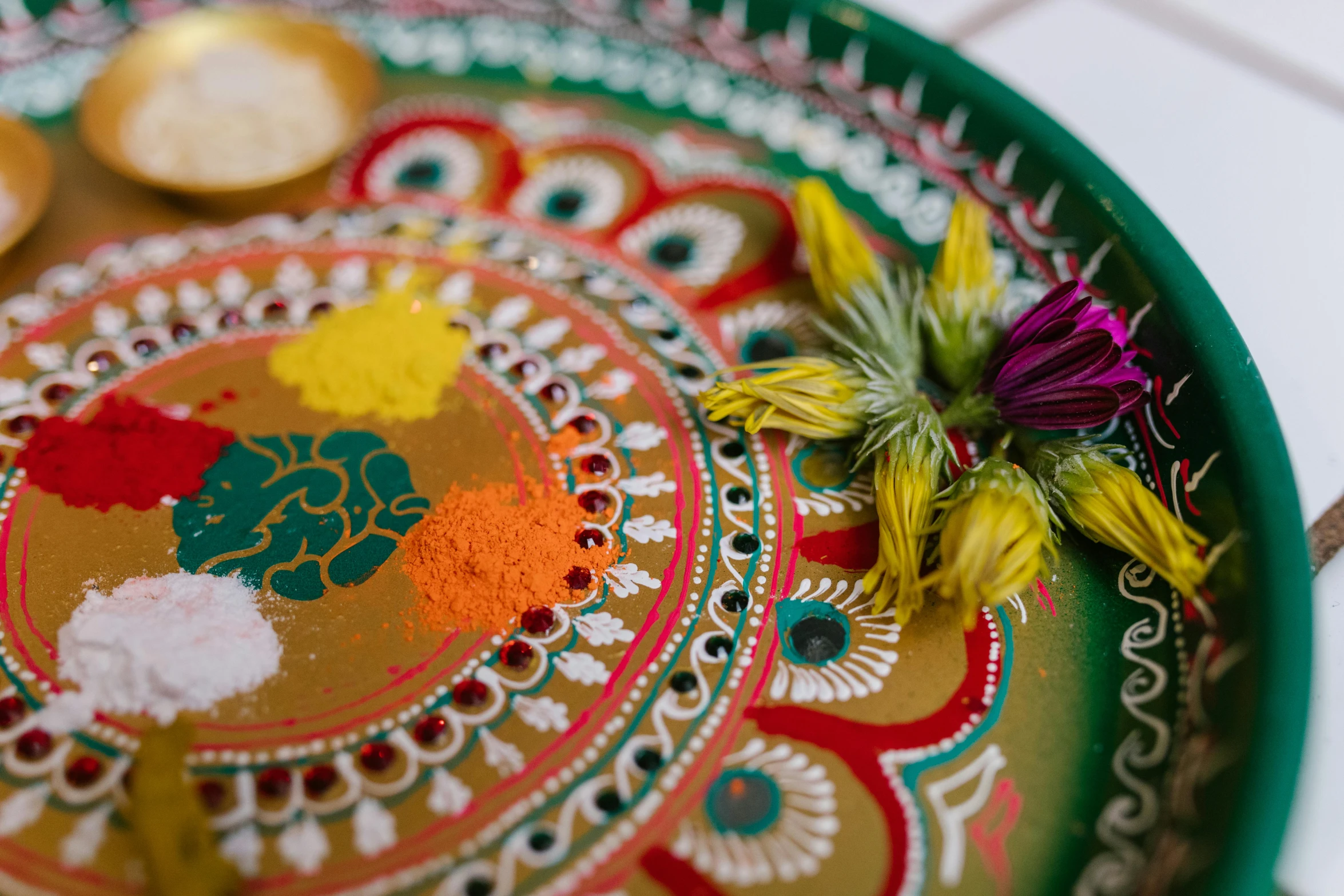 a decorative plate sitting on top of a table, trending on unsplash, holi festival of rich color, high angle close up shot, thumbnail, floral details
