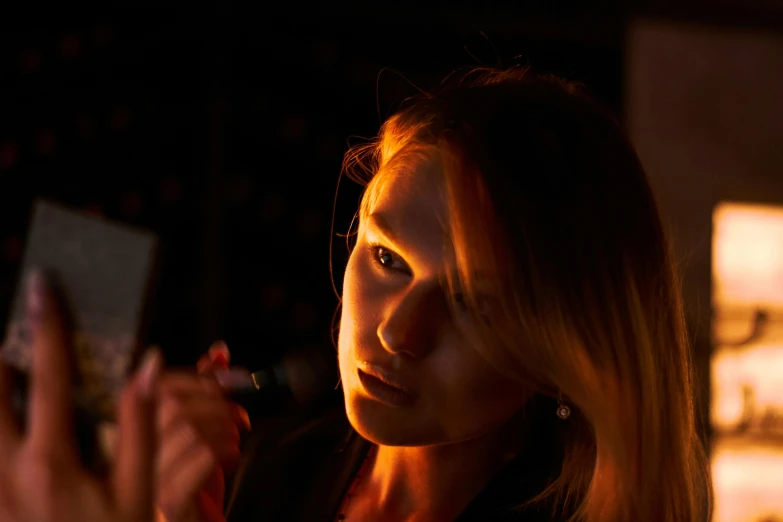 a close up of a person holding a cell phone, a portrait, by Joseph Severn, pexels contest winner, 8 k sensual lighting, olya bossak, holding a microphone, nightcap