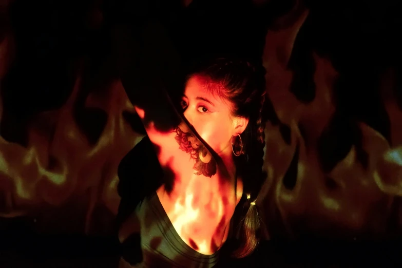 a woman standing in front of a fire, inspired by Elsa Bleda, renaissance, lit from below with red lighting, ariana grande as a sith, taken in 1 9 9 7, fire poi