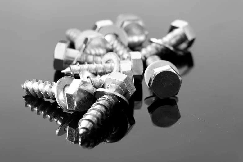 a bunch of screws sitting on top of a table, a black and white photo, by Jan Rustem, pexels, made out of shiny silver, commercial product photography, equine, hexagonal shaped
