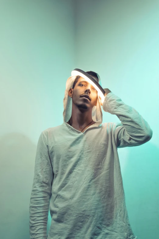 a man wearing a hoodie standing in a room, an album cover, pexels contest winner, light and space, thinking pose, blind brown man, emerging from a lamp, bisexual lighting