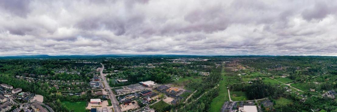 an aerial view of a city on a cloudy day, by Joe Stefanelli, unsplash, realism, woodstock, disaster photography, southdale center, wide long view