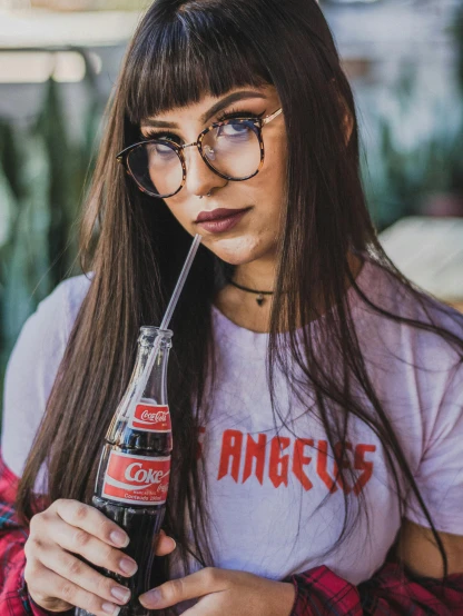 a woman with glasses holding a coke in her hand, inspired by Dorothy Coke, pexels contest winner, young beautiful amouranth, los angeles ca, graphic tees, 5 0 0 px models