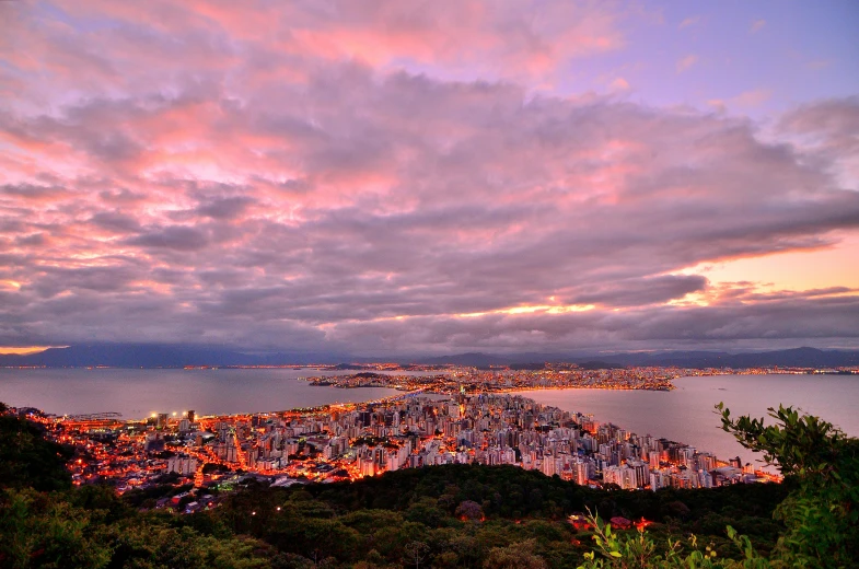 a view of a city from the top of a hill, by Felipe Seade, pexels contest winner, farol da barra, pink skies, 4k panoramic, dramatic”